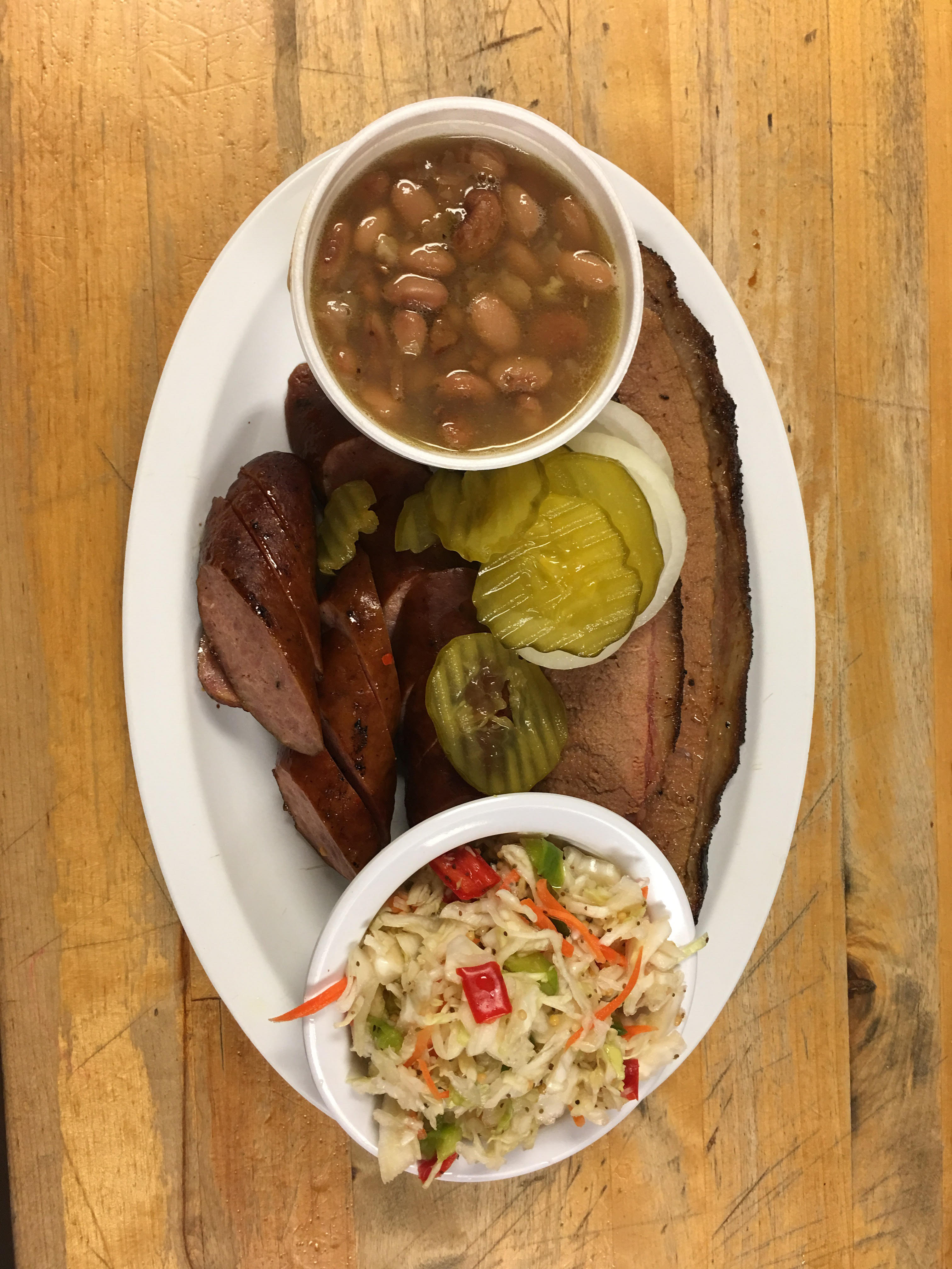 Sliced mesquite-smoked brisket and sausage plate with beans and coleslaw at R & R BBQ in Stephenville, TX