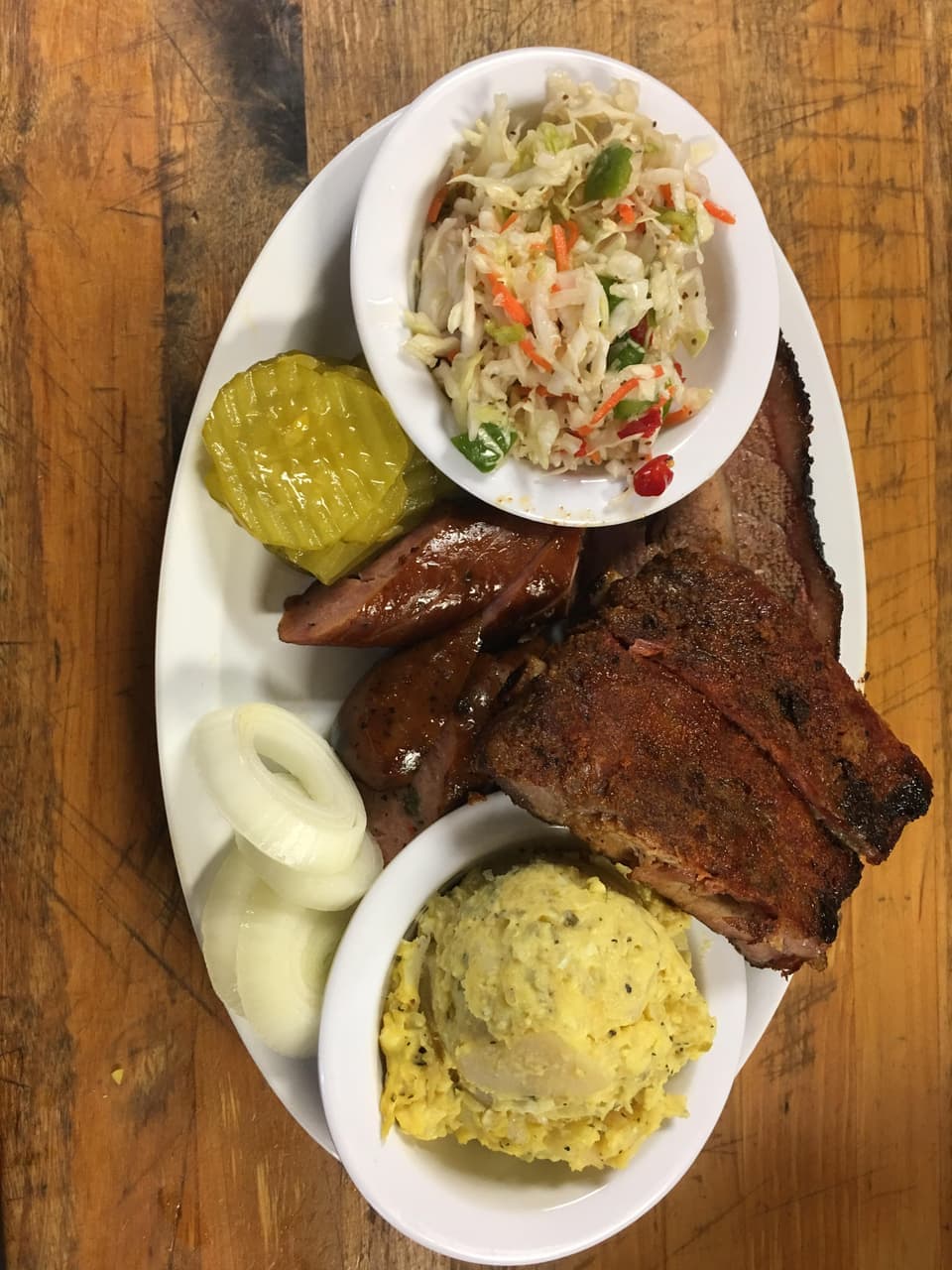Smoked Texas-style ribs served with brisket, sausage, and homemade sides at R & R BBQ