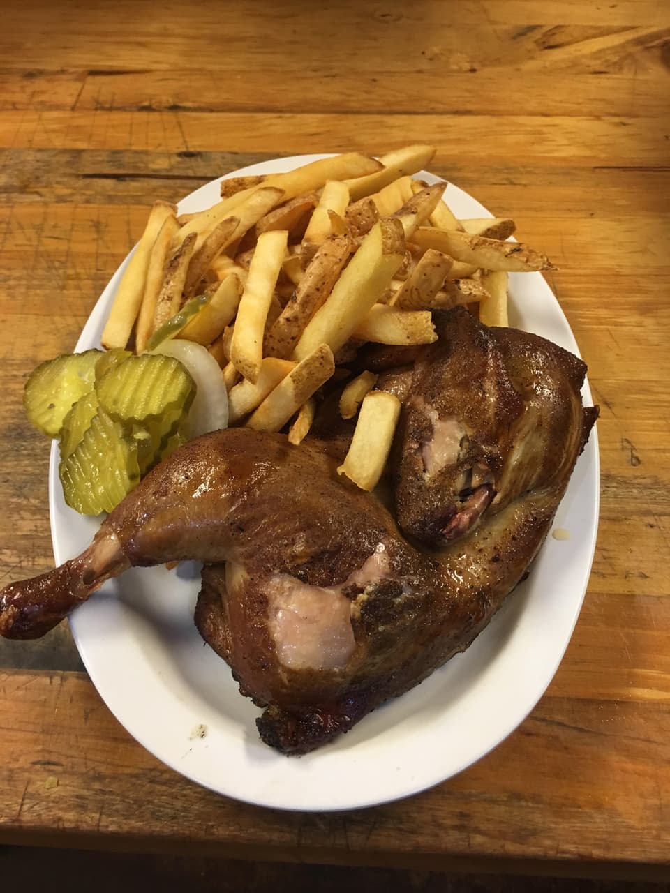 Smoked half chicken plate with fries and pickles at R & R BBQ in Stephenville, TX