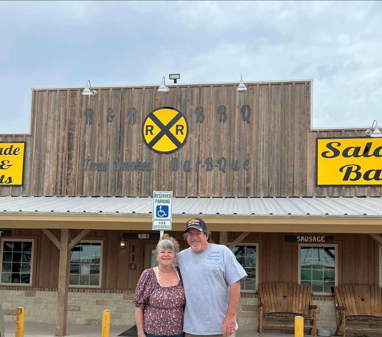 Rod and Tammy standing outside R & R BBQ's storefront on Morgan Mill Rd in Stephenville, TX